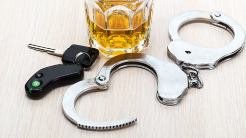 Glass-of-Booze-Surrounded-by-Handcuffs-and-Car-Keys-Belonging-to-Someone-who-Got-a-DUI-in-Detroit-on-a-Holiday