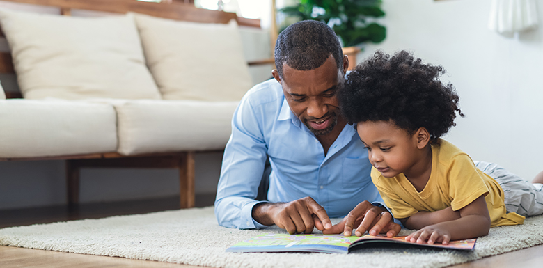 Father reading on floor with todler