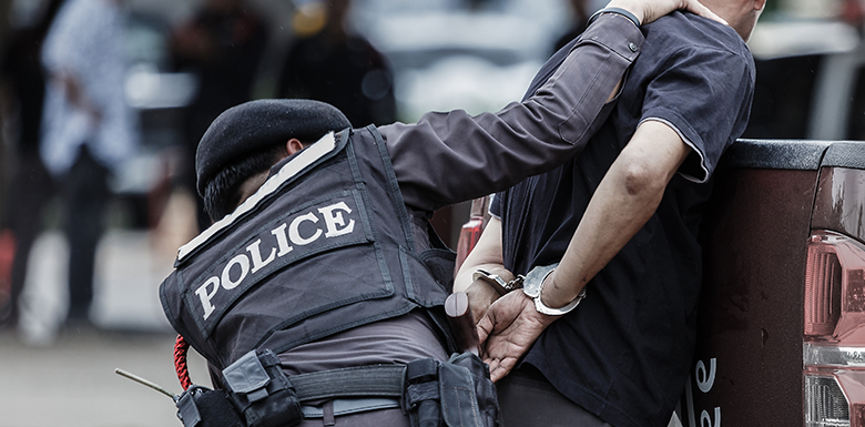 Police officer handcuffing man