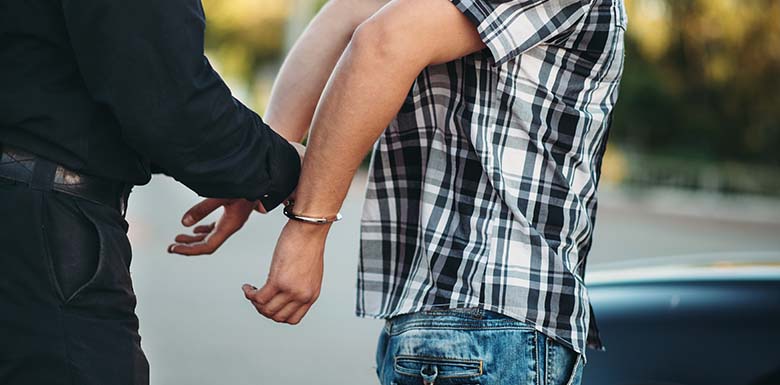 Man in plaid shirt being arrested